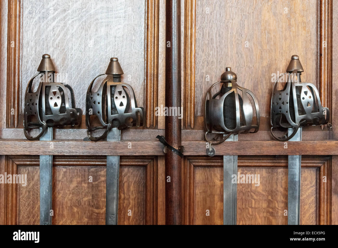 Pommels and hafts of four old medieval swords strapped on a wooden wall in Edinburgh Castle Stock Photo