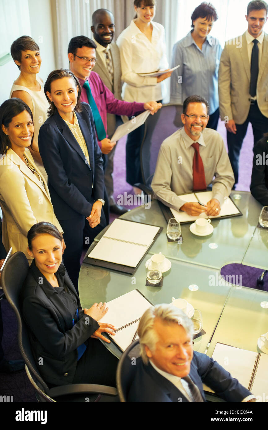 High angle view of smiling business people looking at camera in conference room Stock Photo