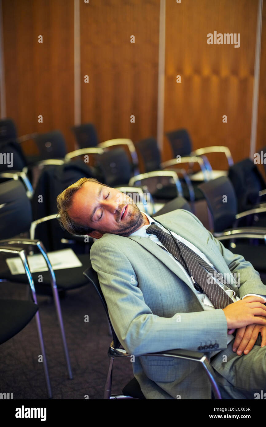 Businessman sleeping in conference room Stock Photo