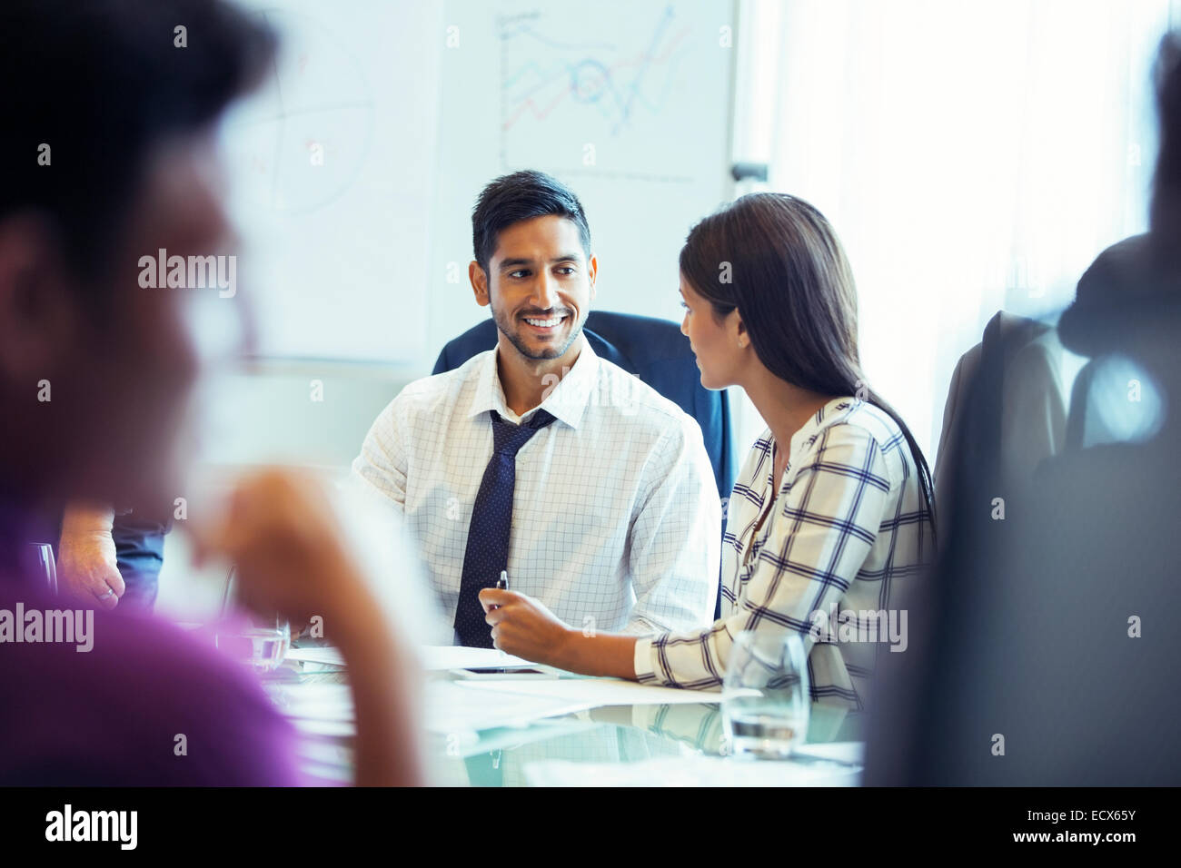 Businesswoman and businessman sitting and talking in conference room during business meeting Stock Photo