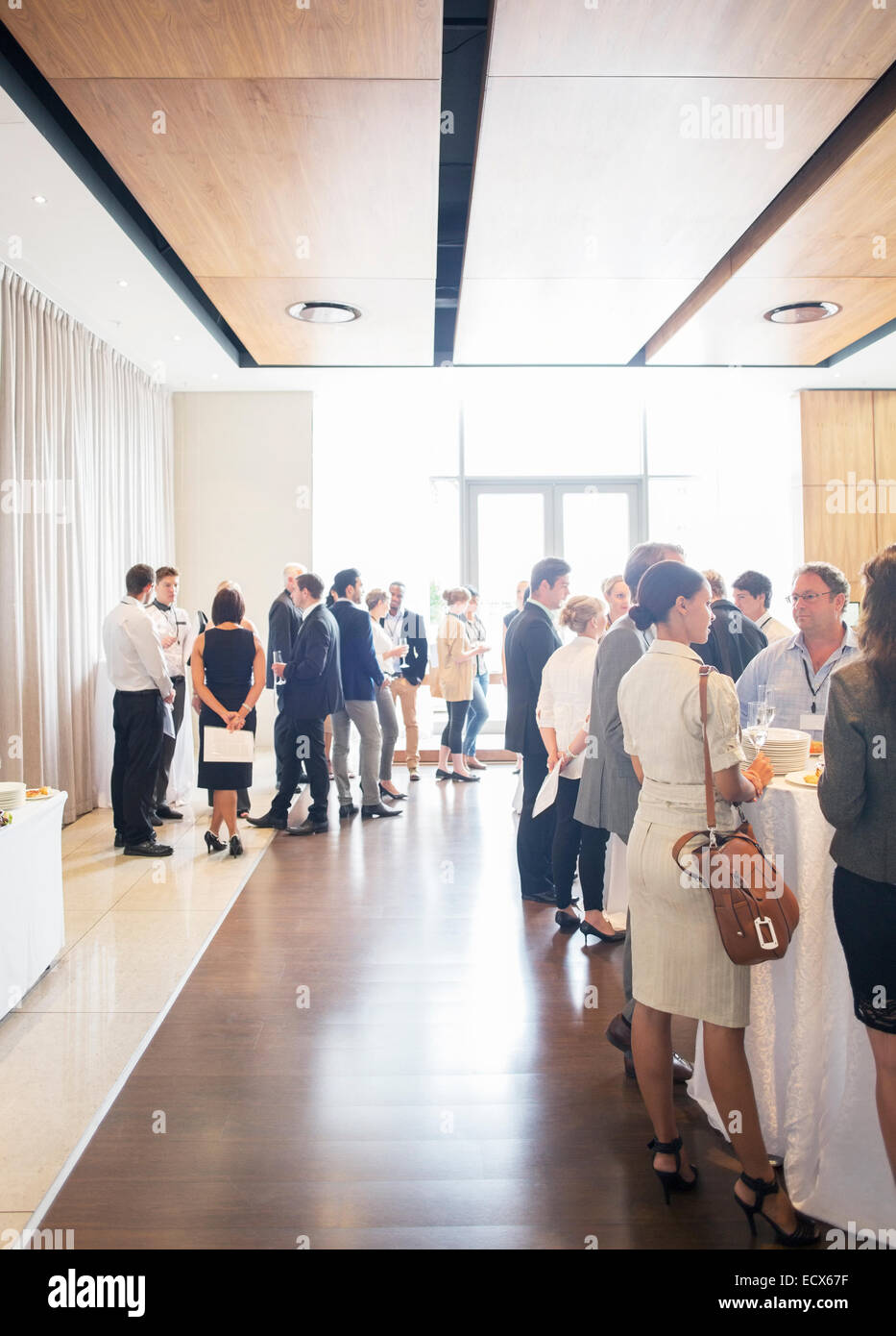 Large group of people socializing in lobby of conference center during coffee break Stock Photo