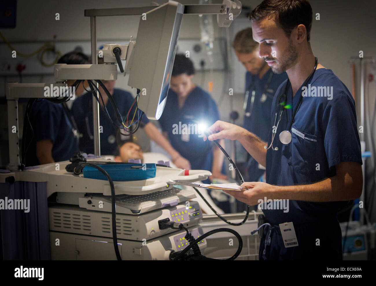 Group of doctors caring for patient in hospital ward Stock Photo