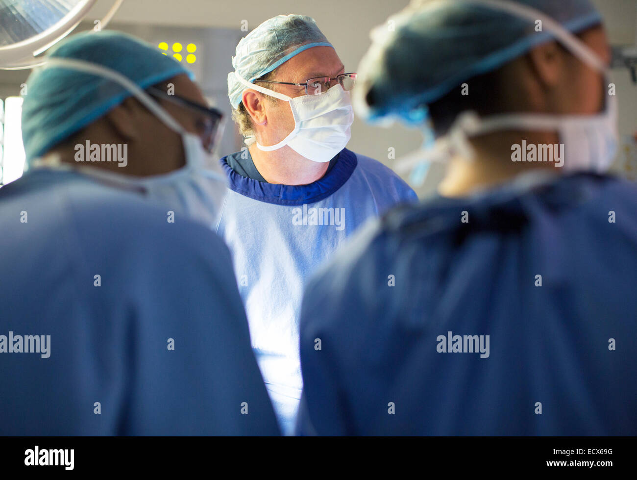 Doctors performing surgery in operating theater Stock Photo