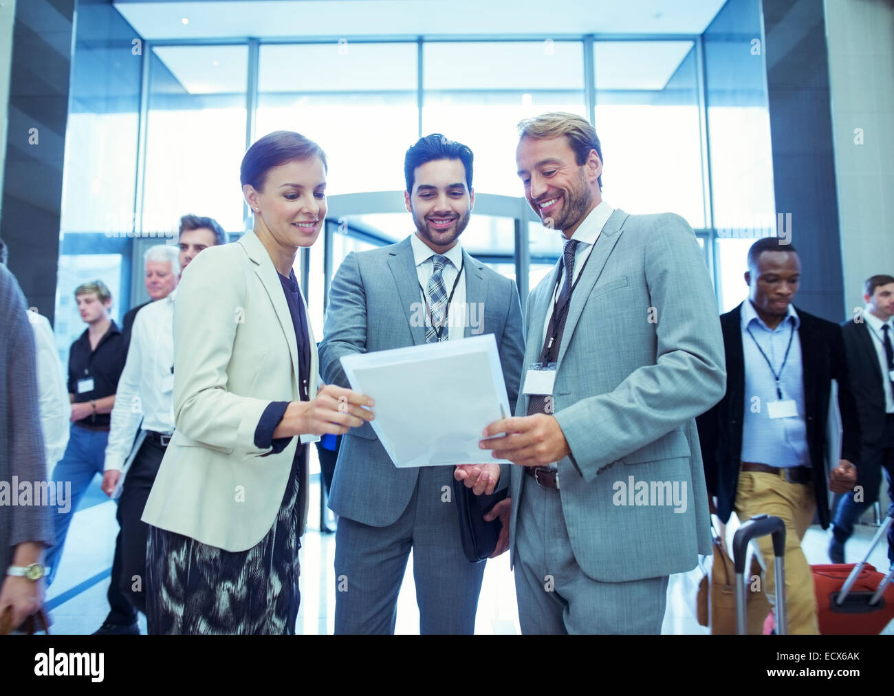 Portrait of businesswoman and two businessmen standing in lobby of conference center Stock Photo