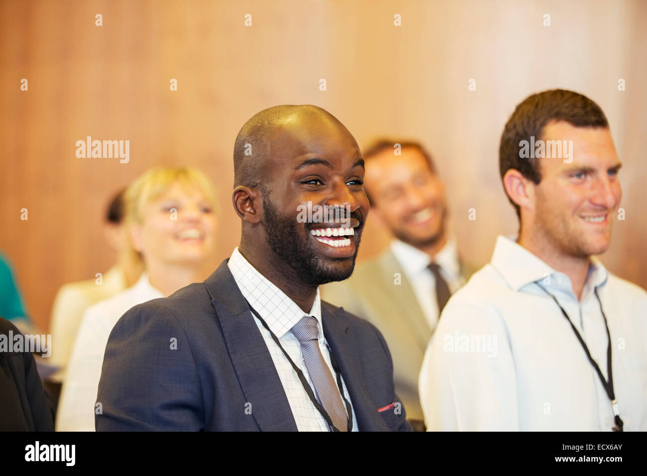 Portrait of two young men, one laughing, sitting in conference room Stock Photo