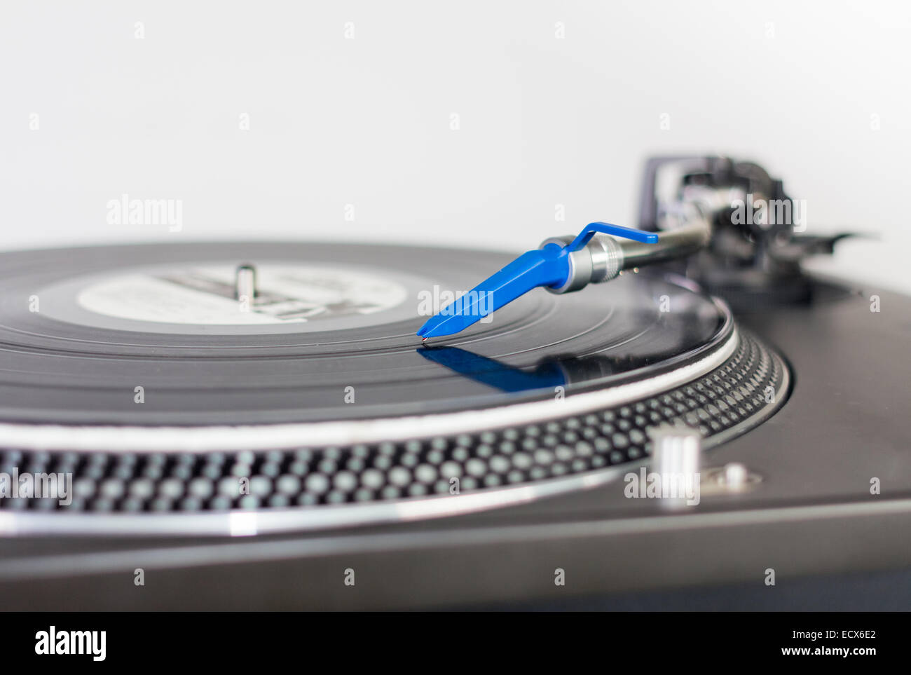 Closeup of a DJ needle on black vinyl record on a classic turntable