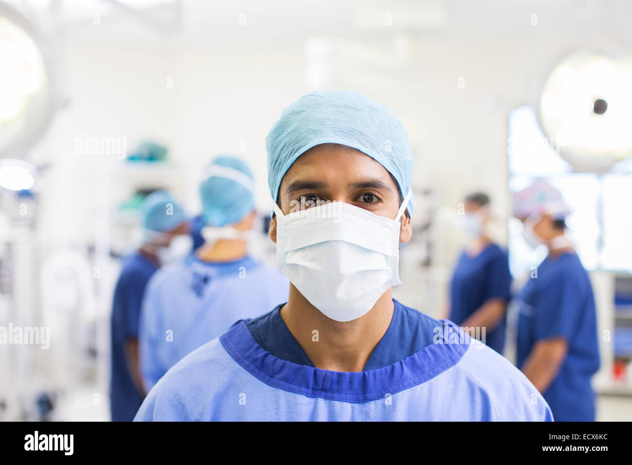 Portrait of surgeon wearing surgical cap, mask and gown in operating theater Stock Photo