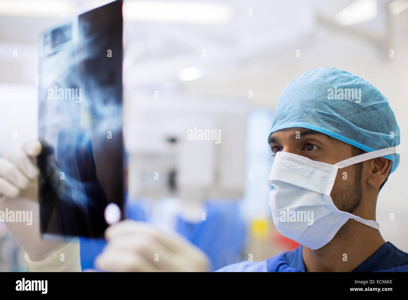 Close up of surgeon wearing surgical cap and mask looking at x-ray in operating theater Stock Photo