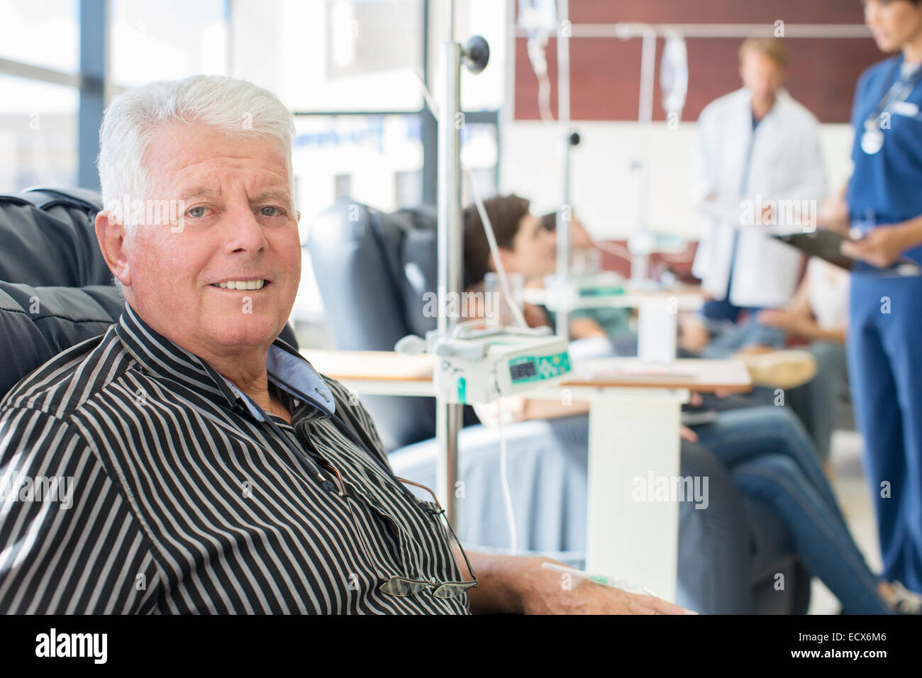 Smiling senior man undergoing medical treatment in outpatient clinic Stock Photo