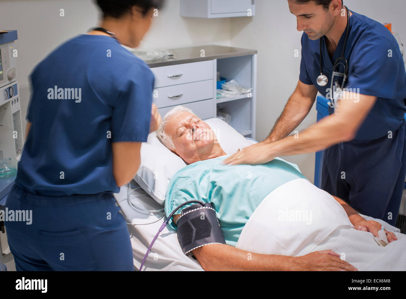 Doctor performing CPR on unconscious patient in emergency room Stock Photo