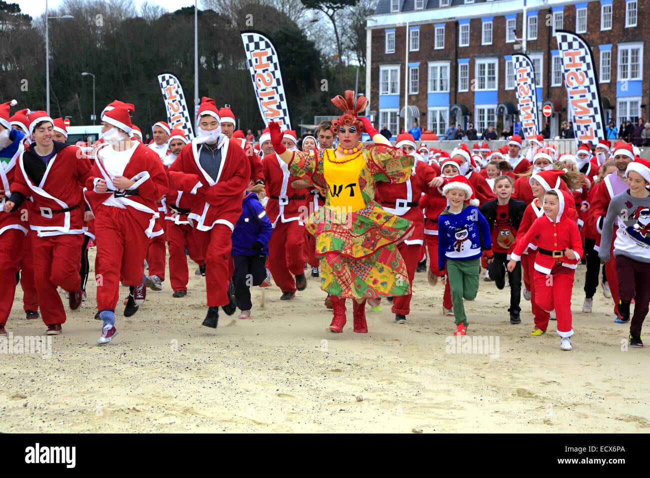 Weymouth, Dorset, UK. 21st Dec 2014. Hundreds of Santas gather at Weymouth for the annual Chase the Christmas Pudding race which takes place on a 5km route along Weymouth's famous beach. Credit:  Tom Corban/Alamy Live News Stock Photo