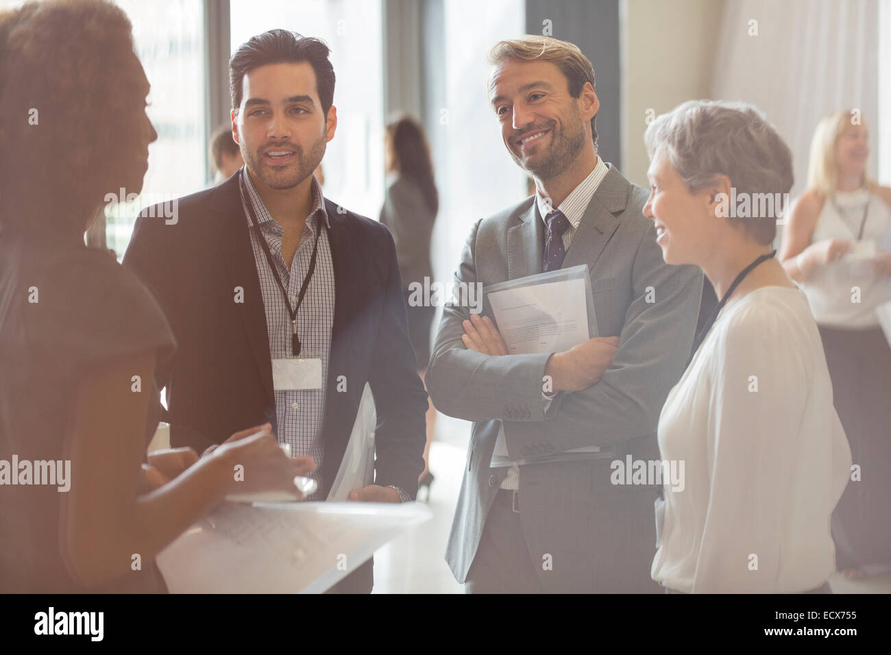 Group of business people smiling and discussing in office Stock Photo ...