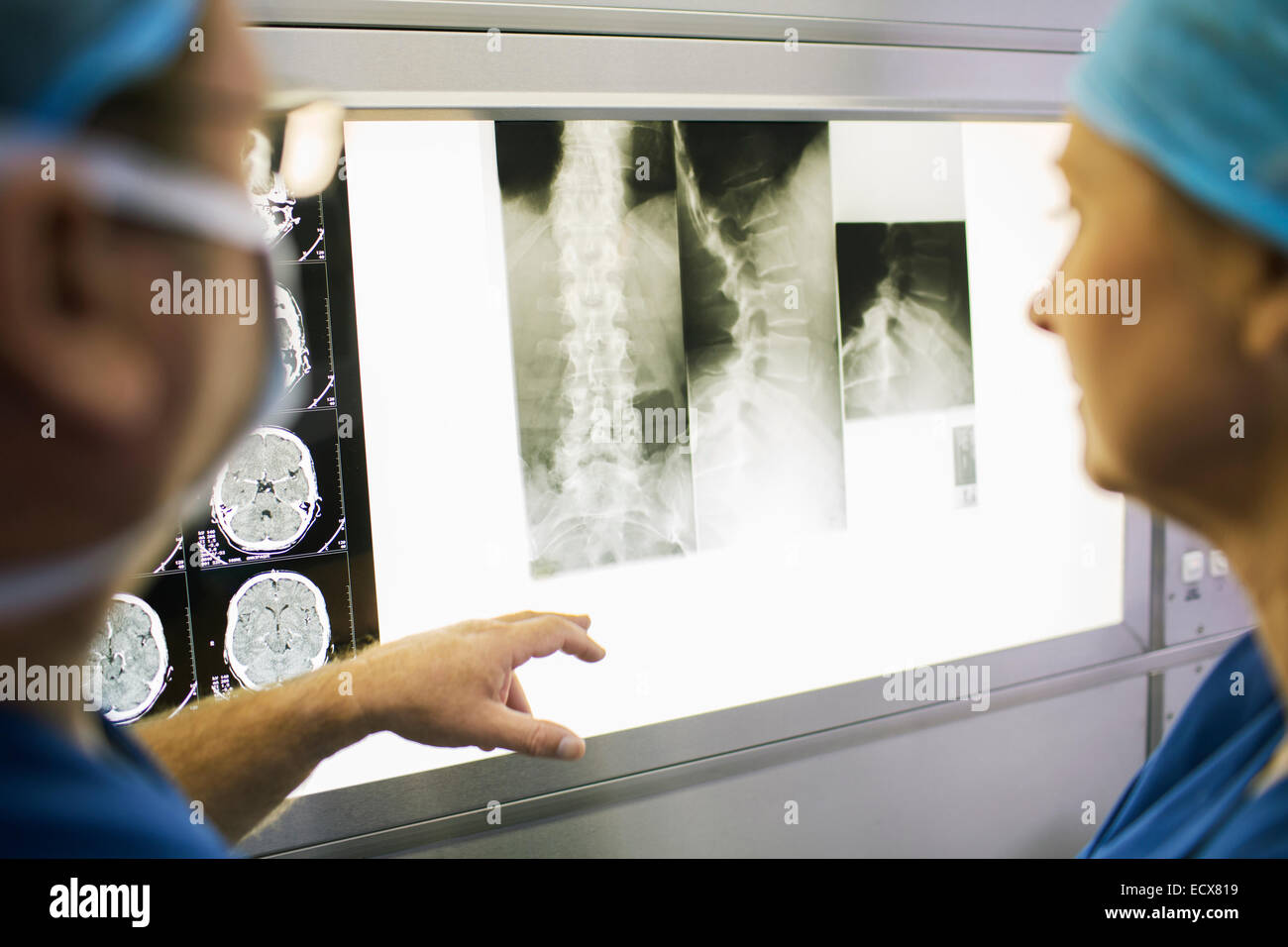 Two mature doctors discussing patient's x-ray and MRI scans Stock Photo