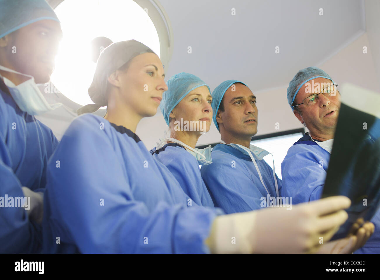 Surgeons looking at x-ray during surgery in operating theater Stock Photo