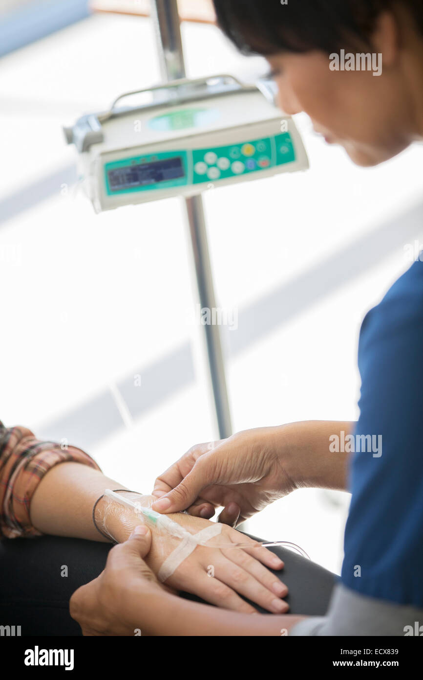 Doctor administering intravenous infusion to patient Stock Photo