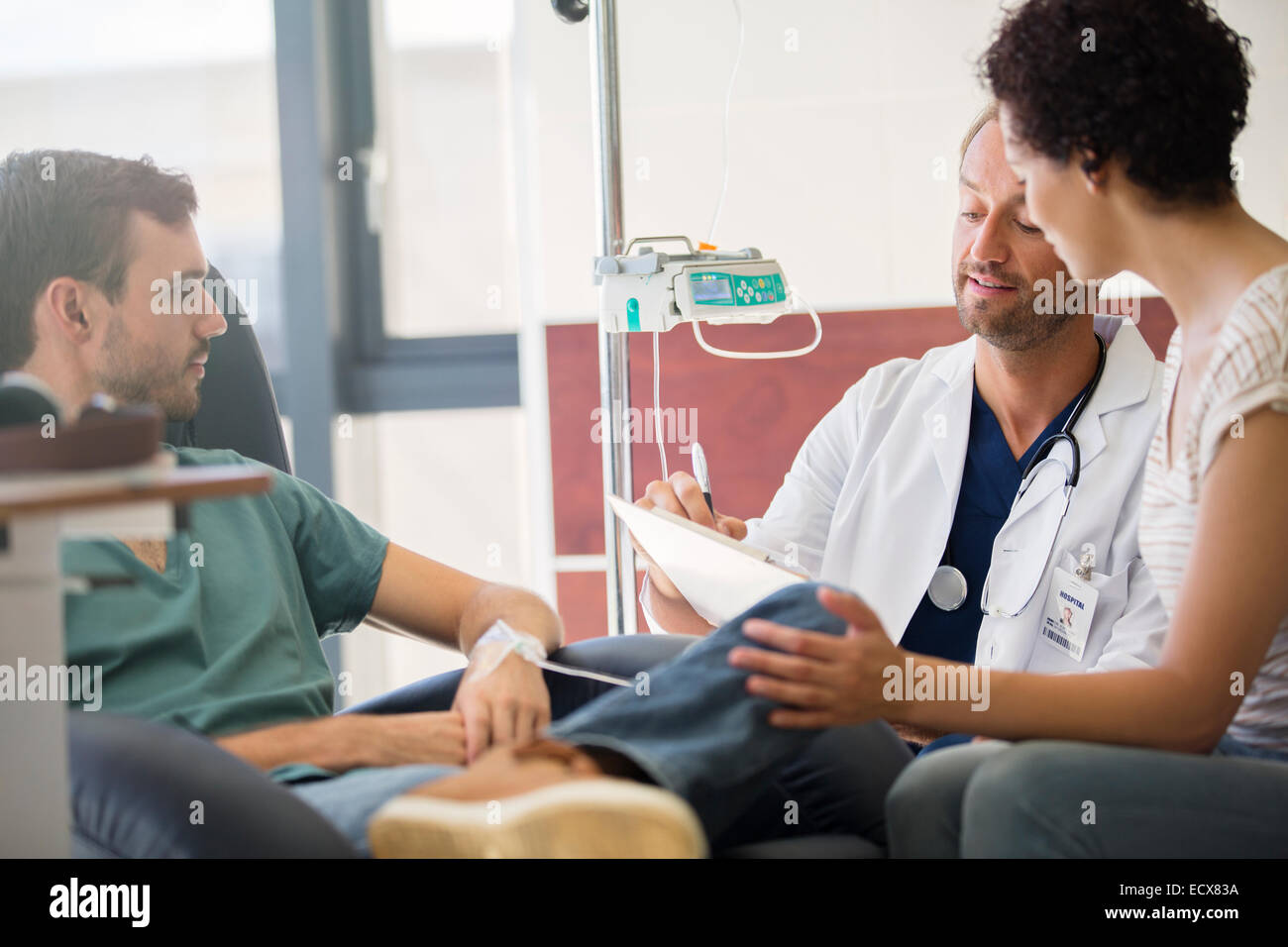 Doctor questioning patient and writing on clipboard Stock Photo