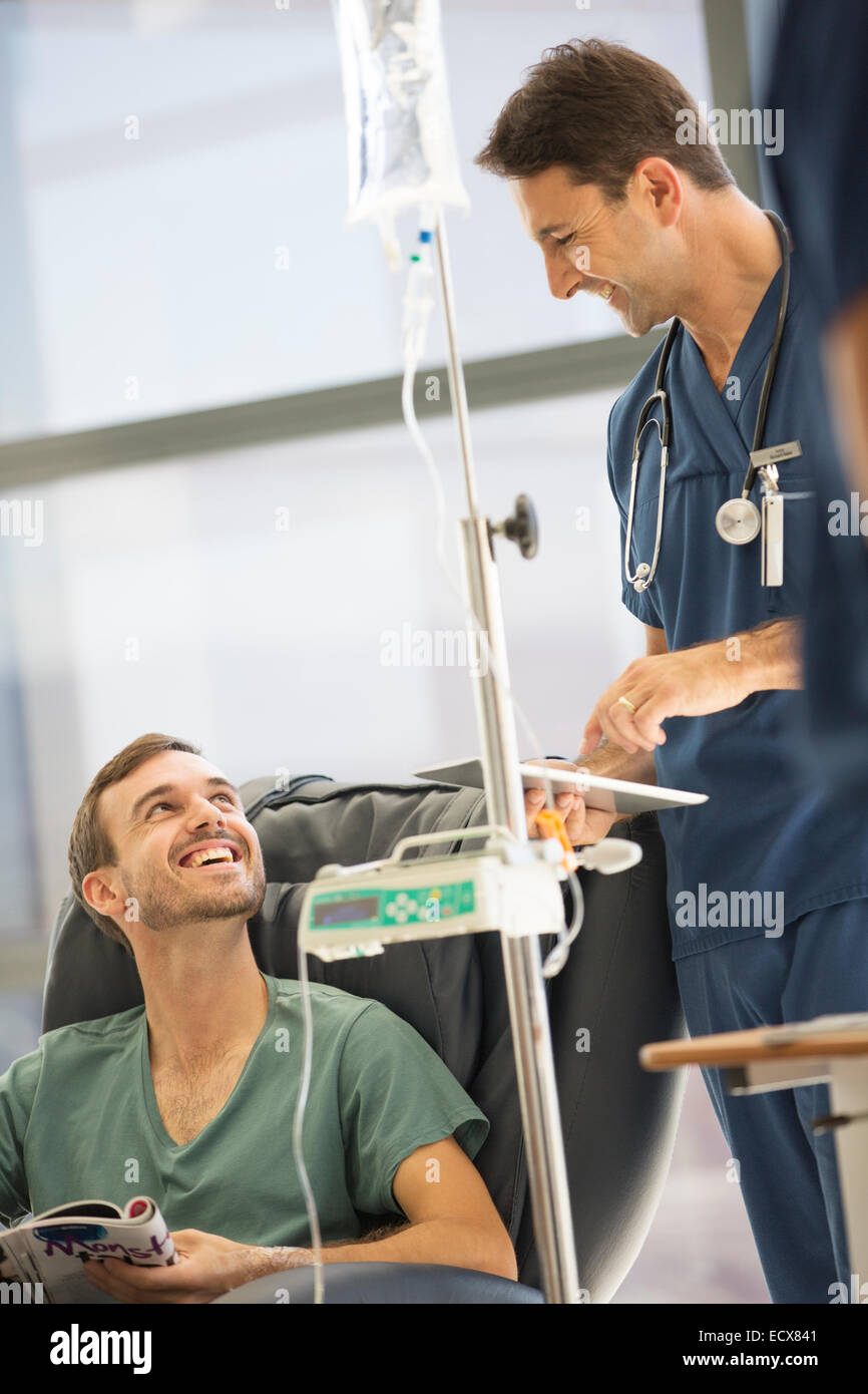 Doctor attending patient receiving intravenous infusion in hospital Stock Photo