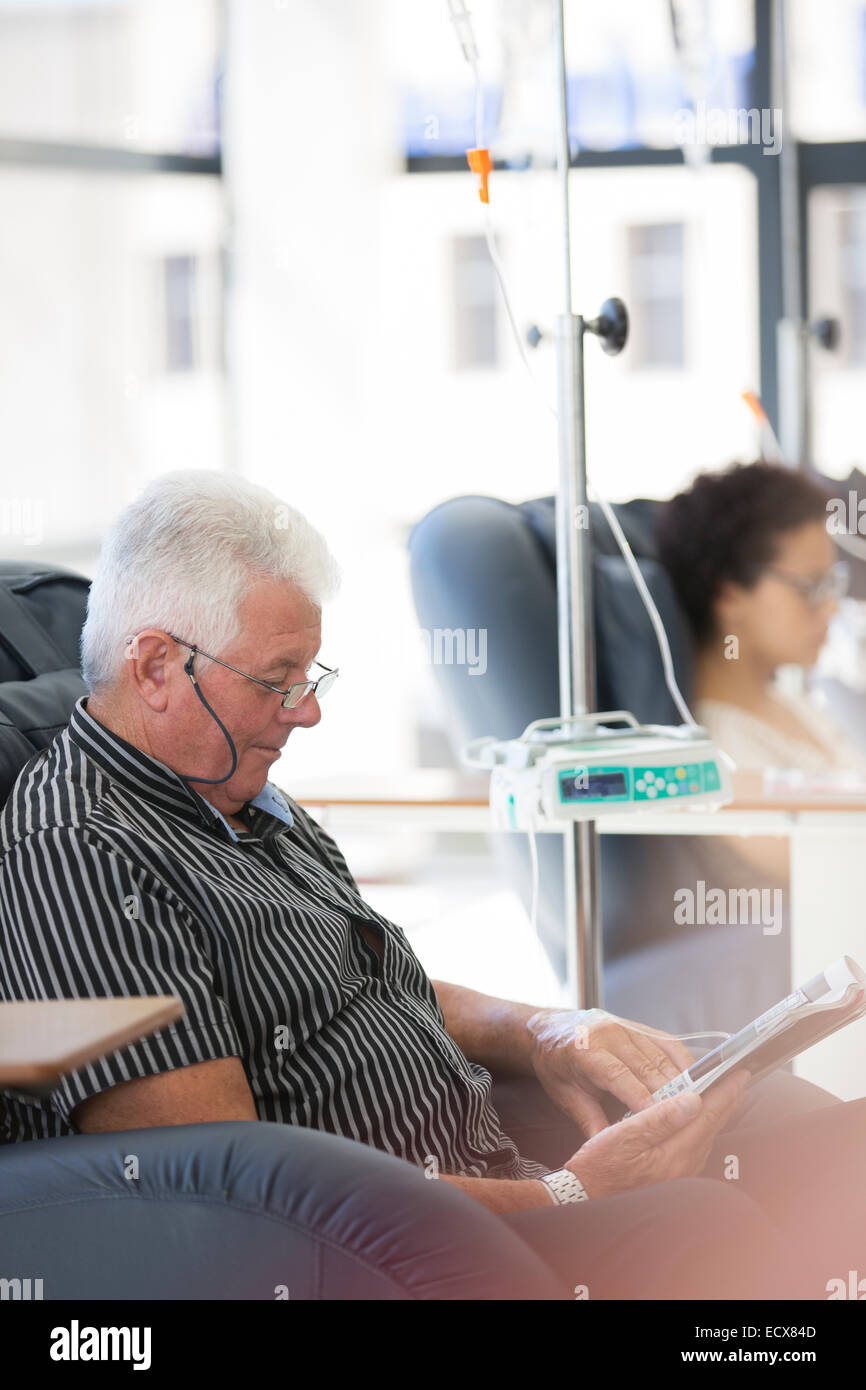 Man reading magazine, undergoing medical treatment in outpatient clinic Stock Photo