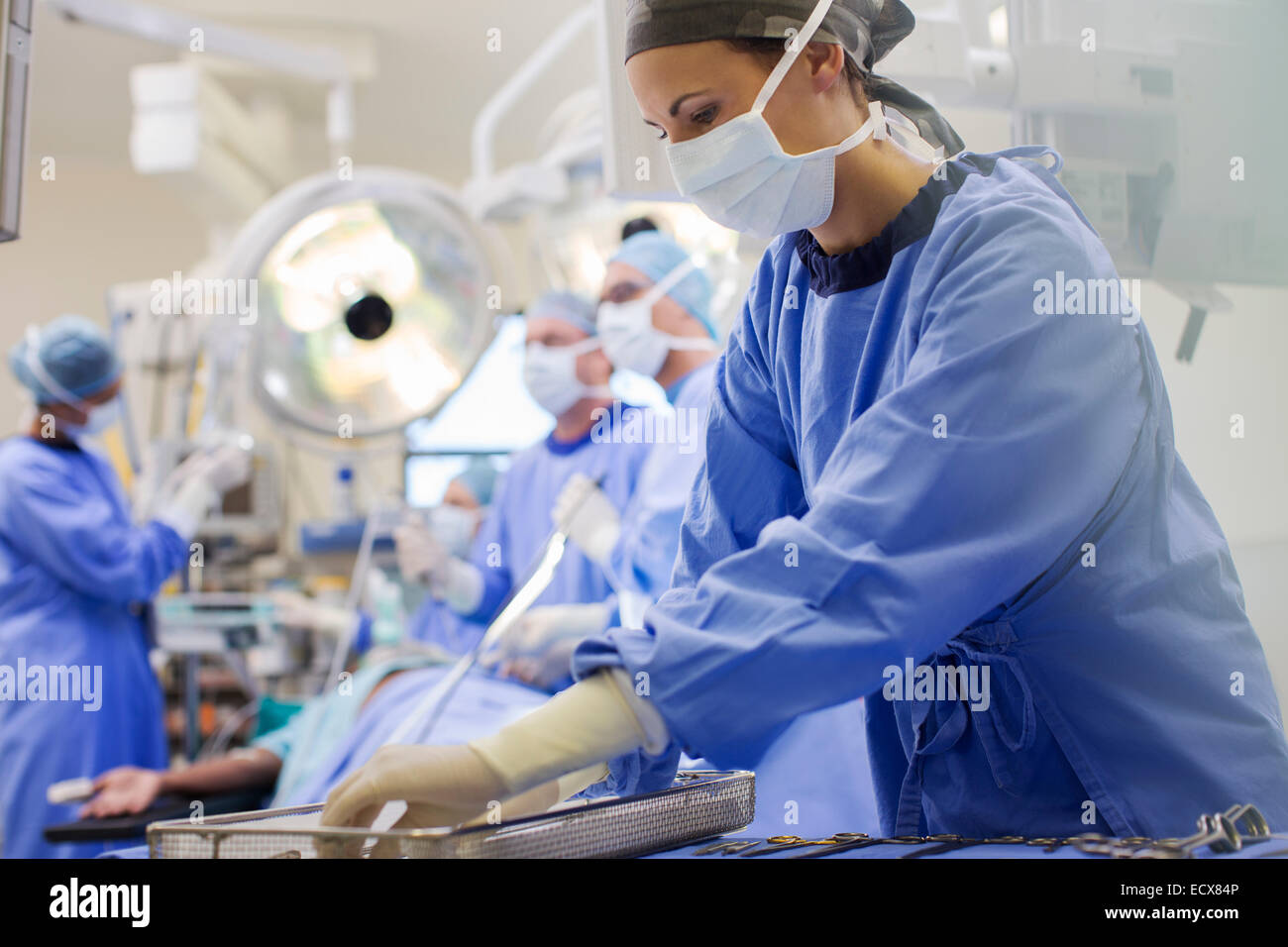 Nurse wearing scrubs preparing medical instruments in operating theater Stock Photo