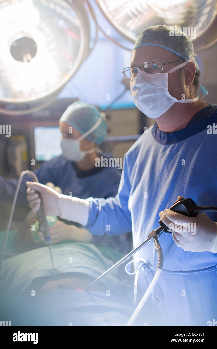Surgeon performing laparoscopic surgery in operating theater Stock Photo