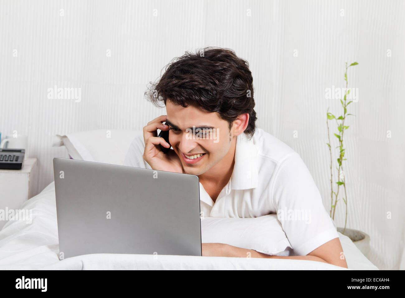 1 indian boy Laptop and talking phone Stock Photo