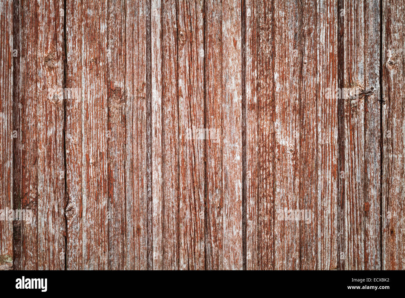 Old gray wooden wall with damaged red paint layer, background photo texture Stock Photo