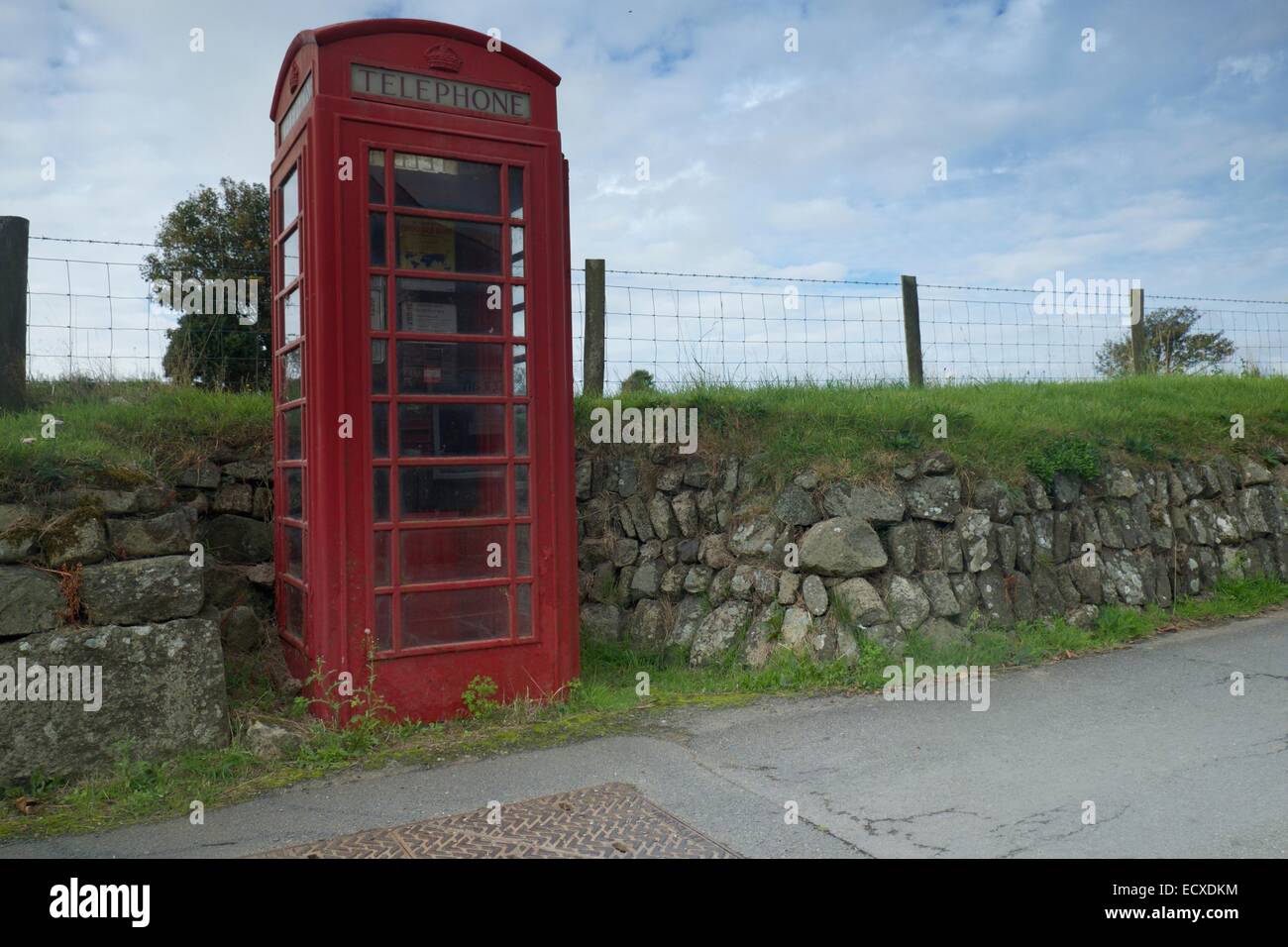 A functioning rural public telephone kiosk recessed into a dry stone wall in a Welsh village in the mobile phone era Stock Photo