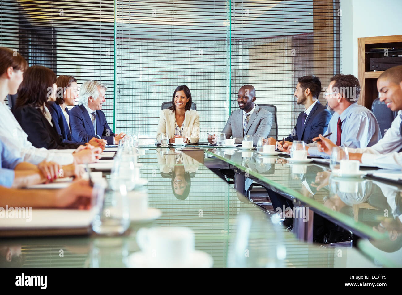 Business people having meeting in in conference room, smiling and discussing Stock Photo