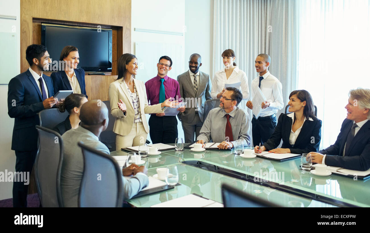 Businesswoman standing at head of conference table and talking Stock Photo