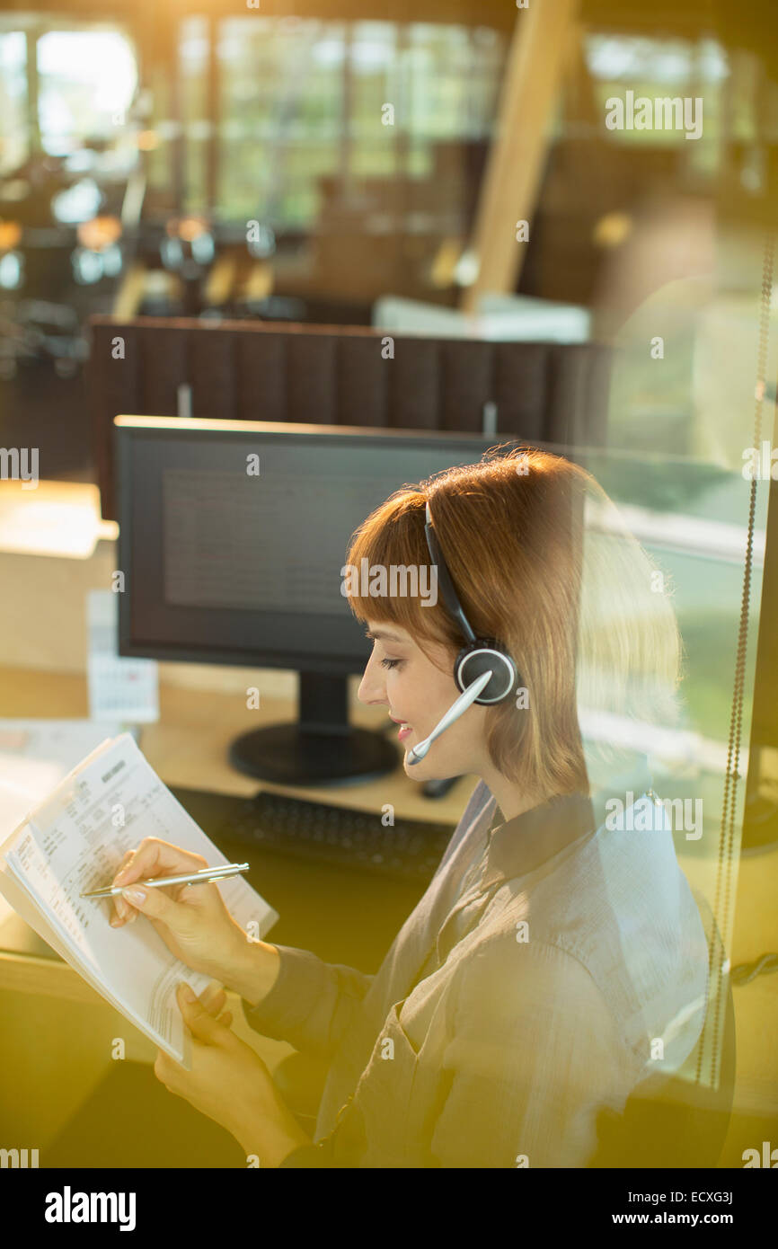 Businesswoman wearing headset and working in office Stock Photo - Alamy