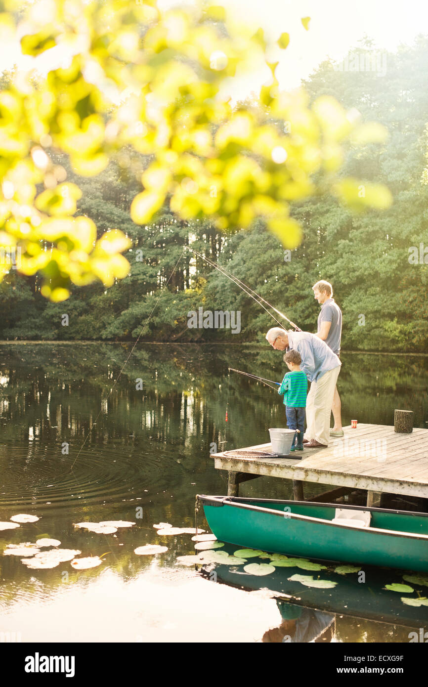 Boy, father and grandfather fishing in lake Stock Photo