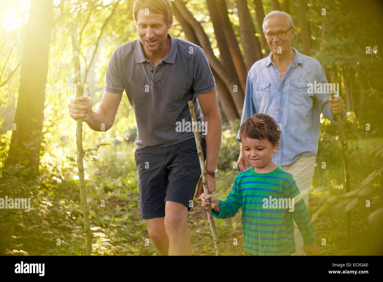 Boy, father and grandfather walking in forest Stock Photo