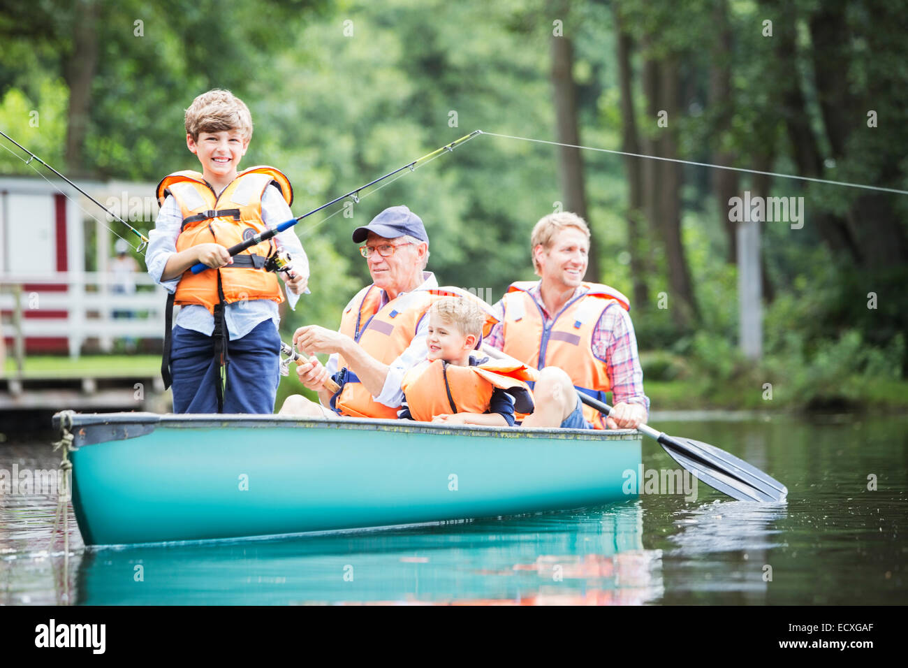 Brothers, father and grandfather fishing in lake Stock Photo
