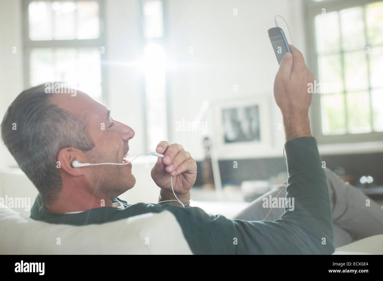 Close up of older man with earbuds talking on cell phone Stock Photo