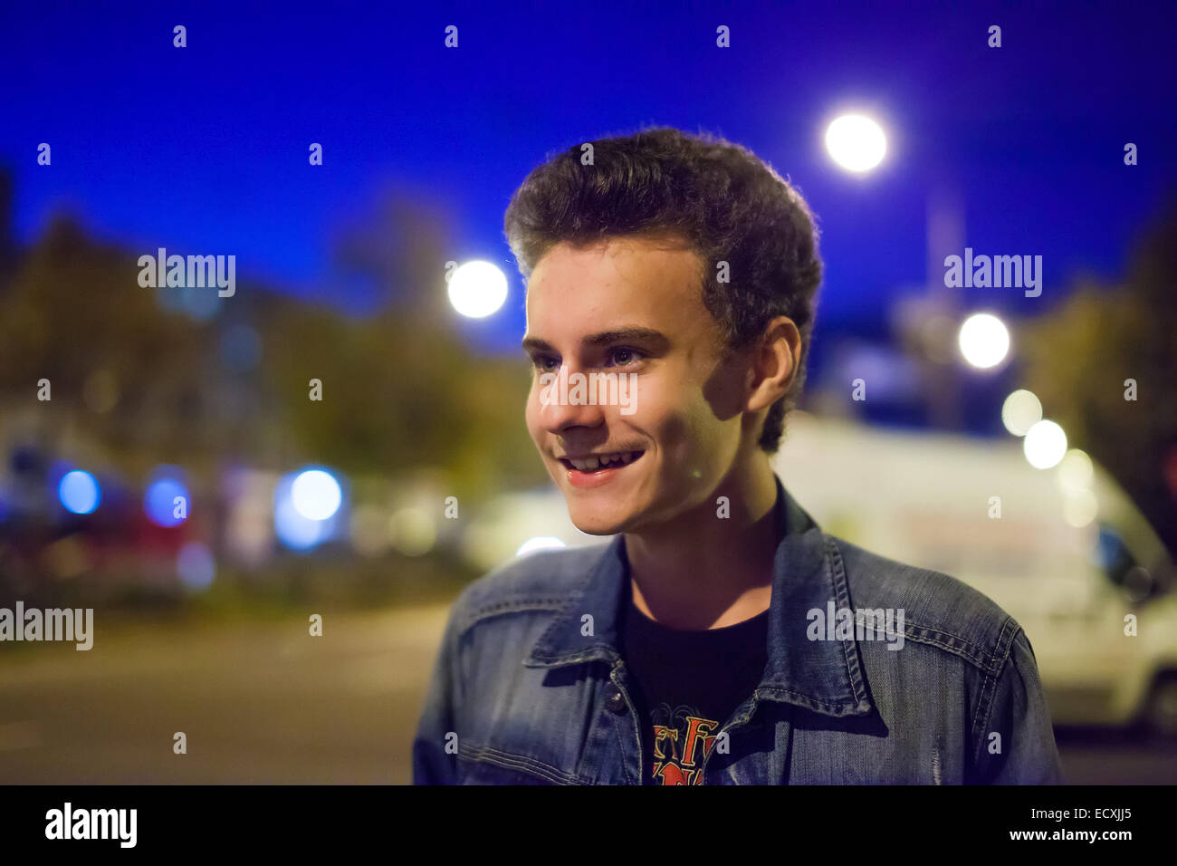 Closeup of a teenage boy in an urban environment at night Stock Photo ...