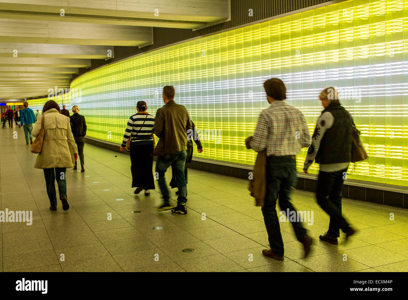 Passengers in an underground passage with a wall of lights Stock Photo