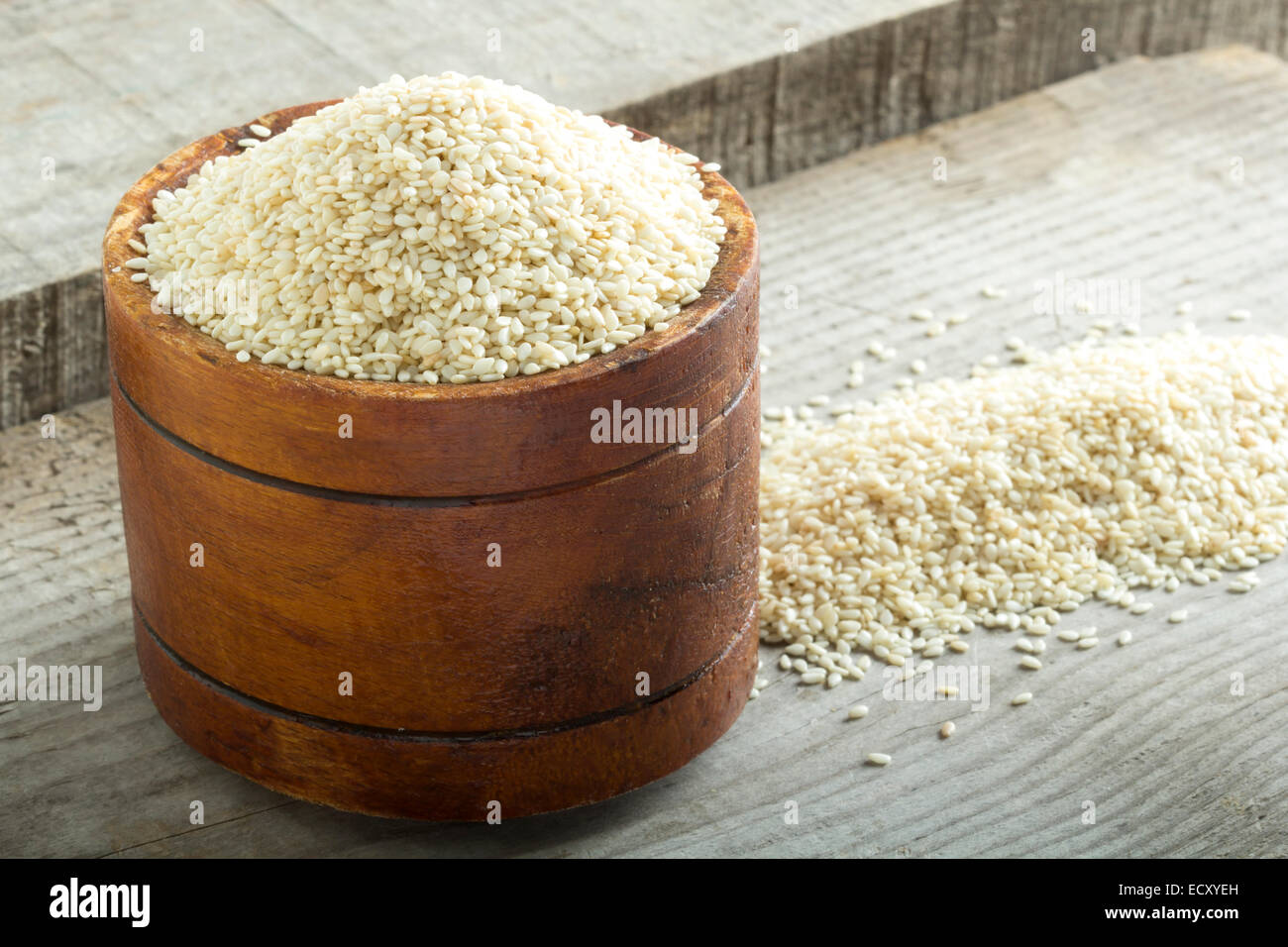Bowl with sesame on old wooden surface Stock Photo