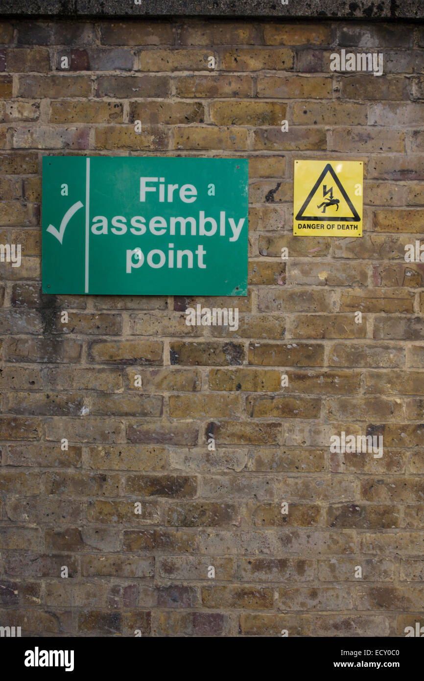 Cointradiction of Fire Assembly Point and Danger of Death signs. Stock Photo