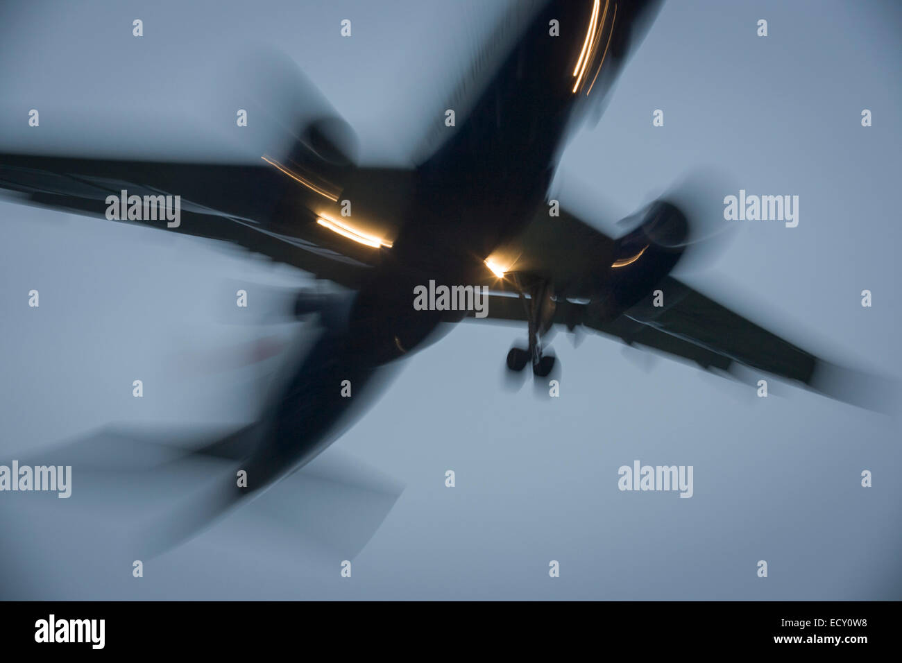 With bright landing lights on, blurred jet airliner lands at London Heathrow airport. Stock Photo