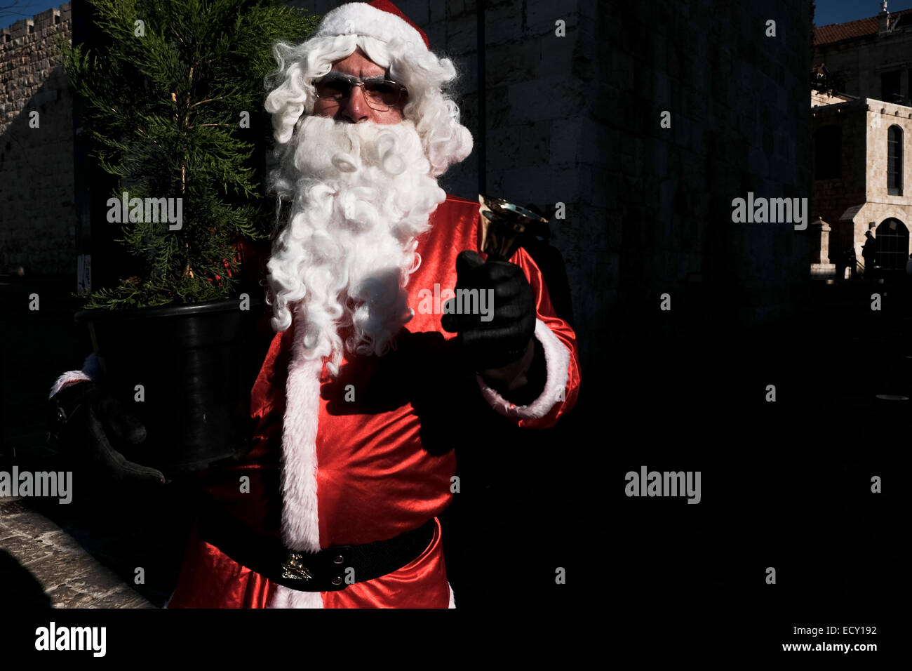 Jerusalem. 22nd Dec, 2014. Santa Claus, or 'Baba Noel' as he is called in the local Arab Christian language, walks on the Old City walls overlooking Jerusalem. The Jerusalem Municipality and the Jewish National Fund distributed specially grown Christmas trees to the Christian population at the Jaffa Gate. Credit:  Nir Alon/Alamy Live News Stock Photo
