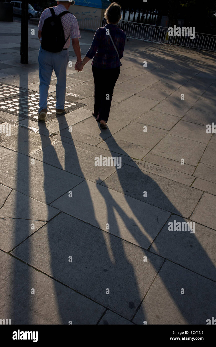 Mature couple walk on London's Southbank in late afternoon. Stock Photo