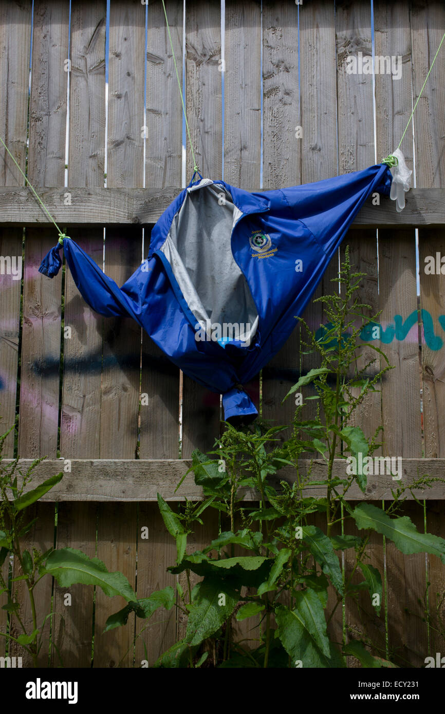 Jacket hanging on fence in risk averse playground called The Land on Plas Madoc Estate, Ruabon, Wrexham, Wales. Stock Photo