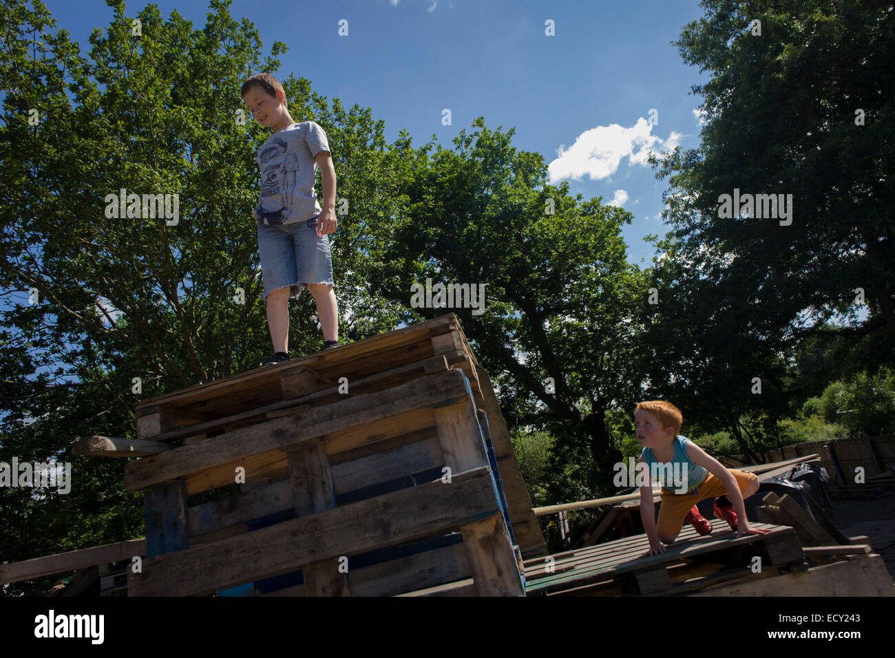 Boys play in risk averse playground called The Land on Plas Madoc Estate, Ruabon, Wrexham, Wales. Stock Photo