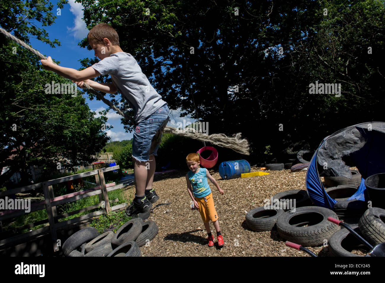 Boys play in risk averse playground called The Land on Plas Madoc Estate, Ruabon, Wrexham, Wales. Stock Photo