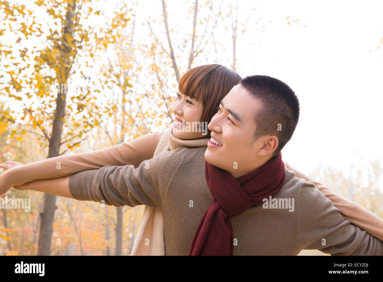 Young couple piggybacking outdoors Stock Photo