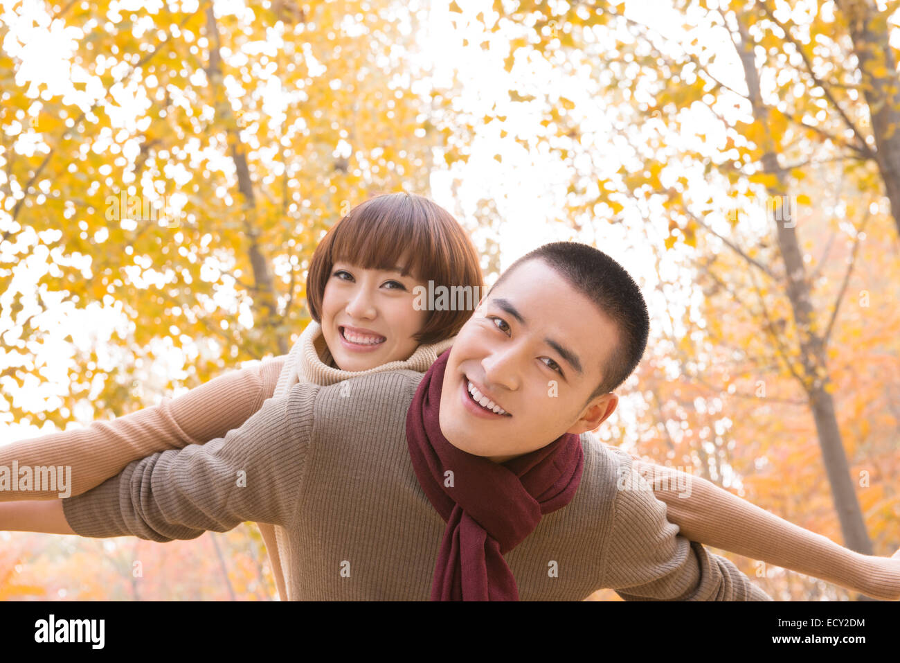 Young couple piggybacking outdoors Stock Photo