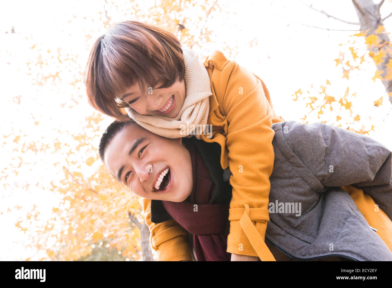 Young couple piggybacking outdoors Stock Photo