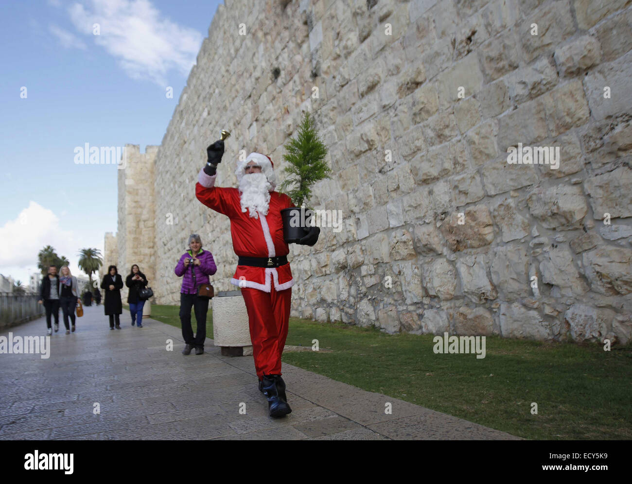 Jerusalem. 22nd Dec, 2014. Issa Kassissieh, an Israeli-Arab Christian, wears a Santa Claus costume as he poses for the media in Jerusalem's Old City, during the annual distribution of Christmas trees by the Jerusalem municipality December 22, 2014 Credit:  Muammar Awad/APA Images/ZUMA Wire/Alamy Live News Stock Photo