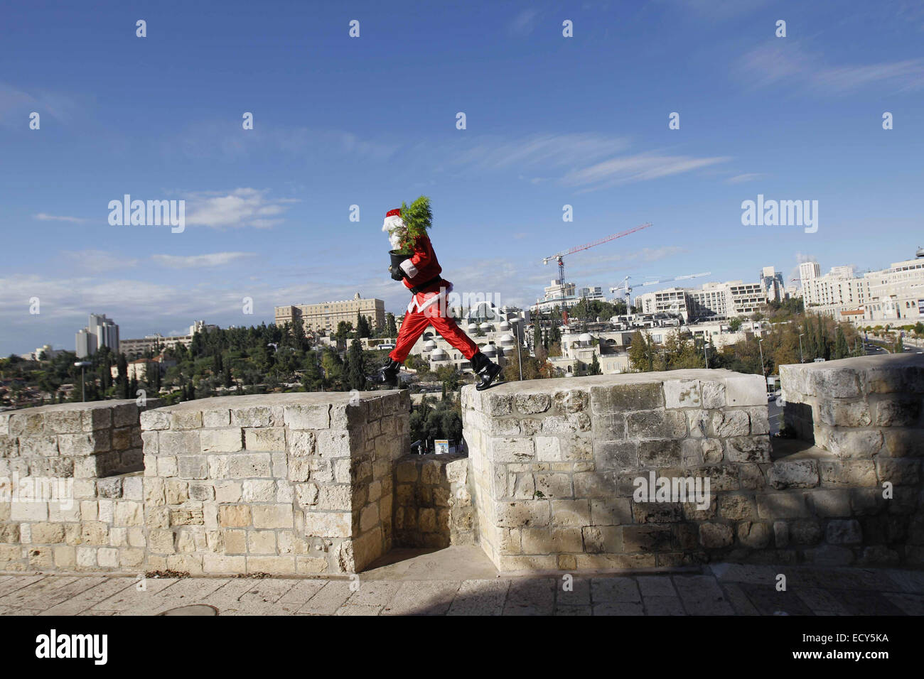 Jerusalem. 22nd Dec, 2014. Issa Kassissieh, an Israeli-Arab Christian, wears a Santa Claus costume as he poses for the media in Jerusalem's Old City, during the annual distribution of Christmas trees by the Jerusalem municipality December 22, 2014 Credit:  Muammar Awad/APA Images/ZUMA Wire/Alamy Live News Stock Photo