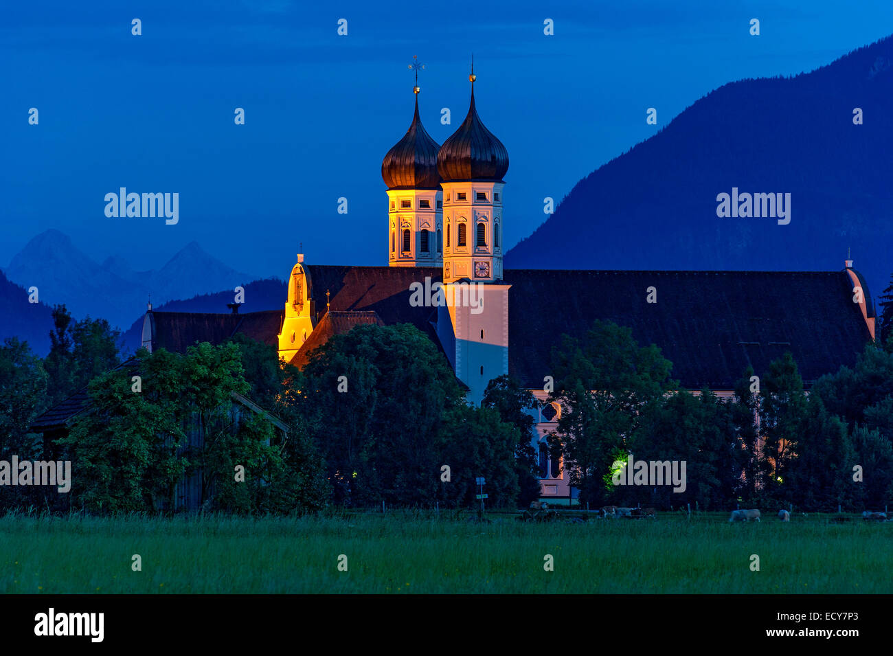 Basilica of St Benedict, Benedictine monastery Benediktbeuern, rear right Herzogstand of the Alps, in the back Arnspitze Group Stock Photo